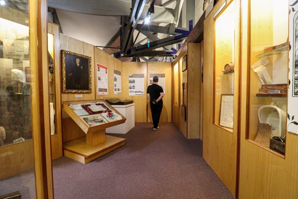 Second section of museum with carpeted path and exhibits on both sides.