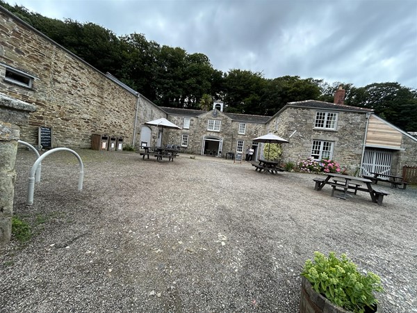 Image of picnic benches outside a stone building