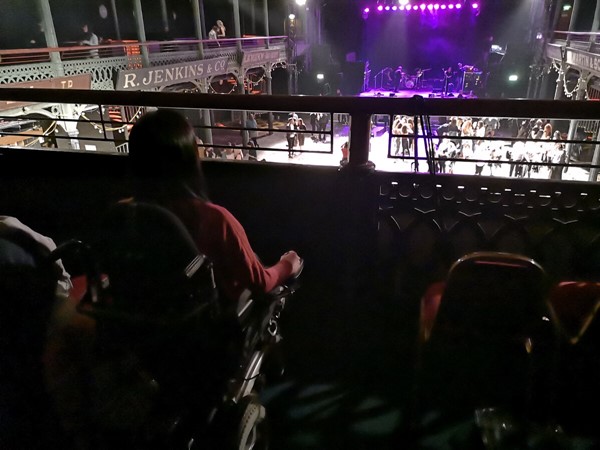 Accessible balcony area with restricted view of the stage due to balcony railing.