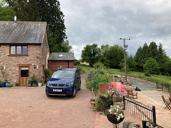 Picture of a car parked outside a cottage