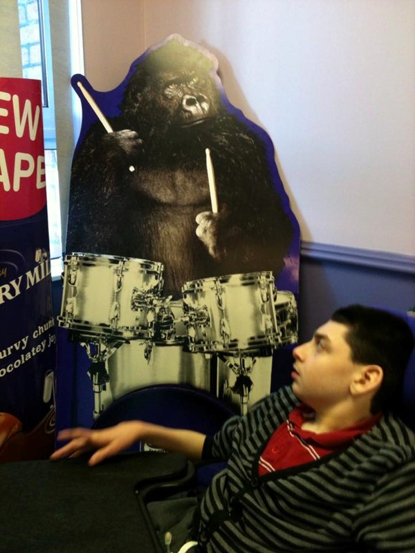 Picture of John-Luke looking at the standup poster at Cadbury World of the gorilla playing the drums