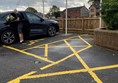 Picture of a man with flowers parked in the disabled parking space car park