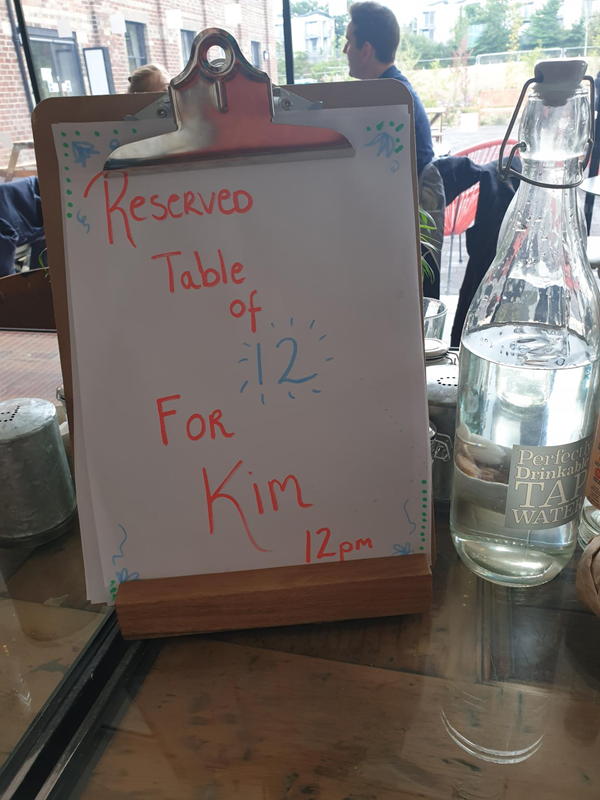 Board saying Reserved for party of 12 for Kim.