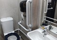 Accessible toilet with grab rails.