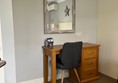 Image of a mirror a desk and a chair