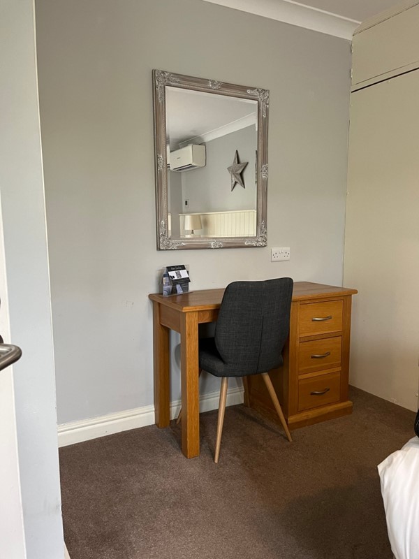 Image of a mirror a desk and a chair
