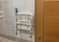 A pull down seat which is infront of the shower and is also in reach of the Red Cord