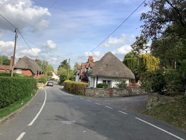 Road going by a small thatched cottage
