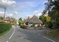 Road going by a small thatched cottage