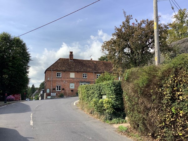 Road leading to a red brick house