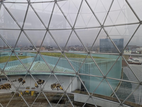 Image of views from The Dome, viewing platform. The sky is grey but you can see grass-topped buildings.
