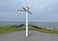 The tall white signpost at John o' Groats indicating directions to Edinburgh, Orkney, New York and Shetland.