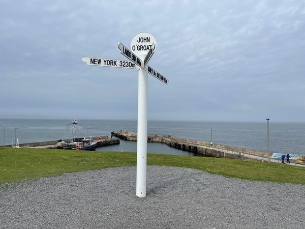 The tall white signpost at John o' Groats indicating directions to Edinburgh, Orkney, New York and Shetland.