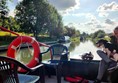 Picture of a canal boat deck with two plastic garden chairs and a  lifebuoy