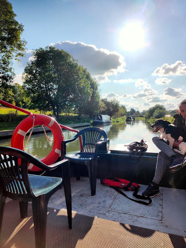 Picture of a canal boat deck with two plastic garden chairs and a  lifebuoy