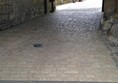 Archway with cobbles but there is level paving to the left through the archway.
