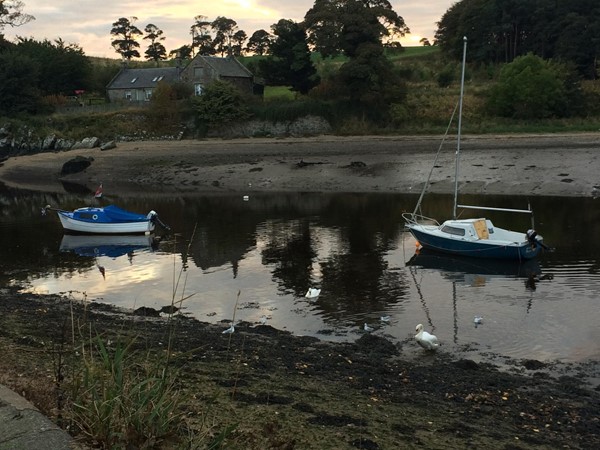 Photo of boats where the river meets the coast.