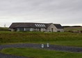 Picture of  a concrete building a football pitch and two bottles of water