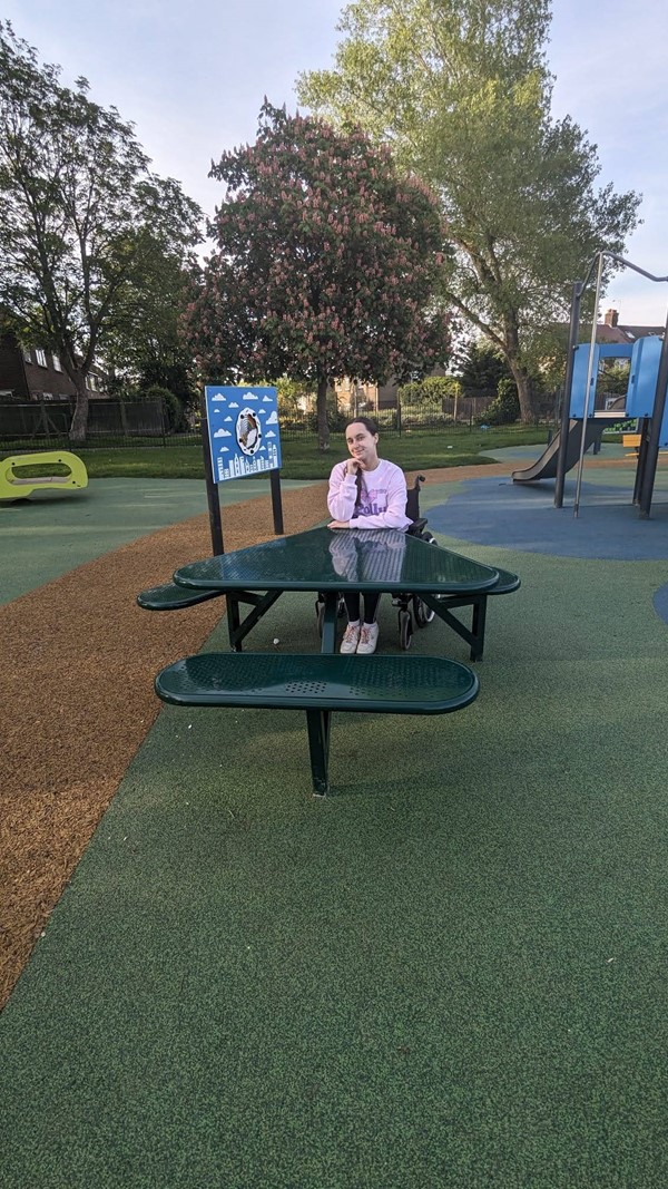 Image of reviewer sitting at wheelchair accessible picnic table.