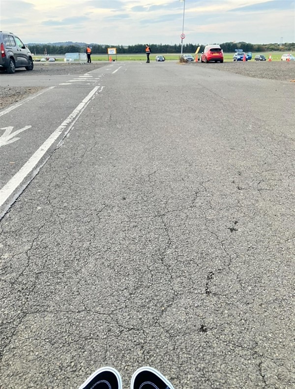 Image of a walkway by a car park