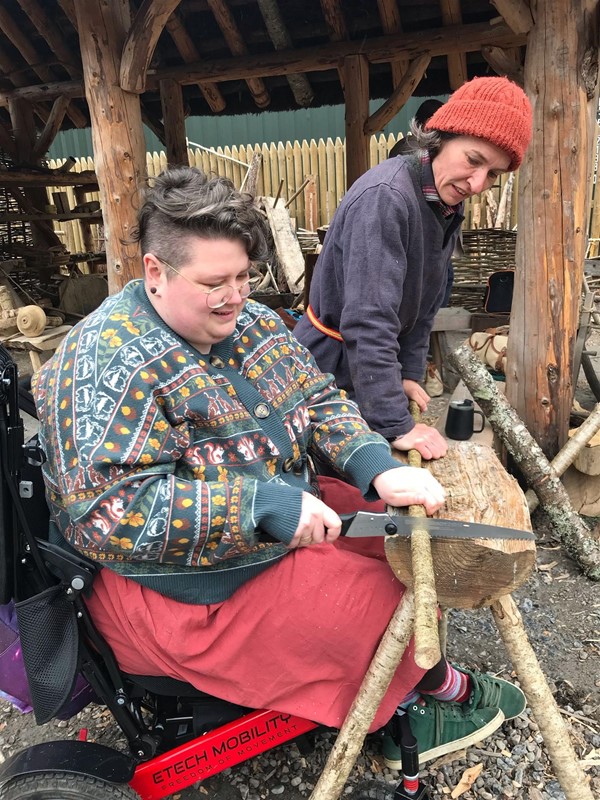 Image of a wheelchair user sawing wood