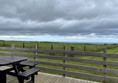 Picture of a picnic bench on decking overlooking a field