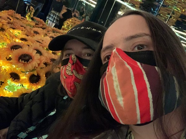 Picture of visitors in facemasks in front of sunflowers