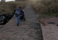 Image of a person wheeling a child up a concrete ramp