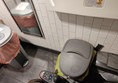 Multiple bins obstructing the toilet, impossible for a wheelchair user to turn and manoeuvre, impossible to park next to the toilet to transfer sideways.
