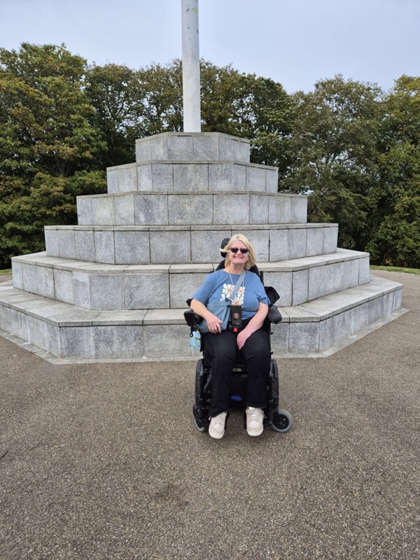 Image of a wheelchair user in front of a memorial
