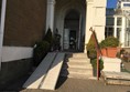 Image of main entrance with ramp and step at doorway.