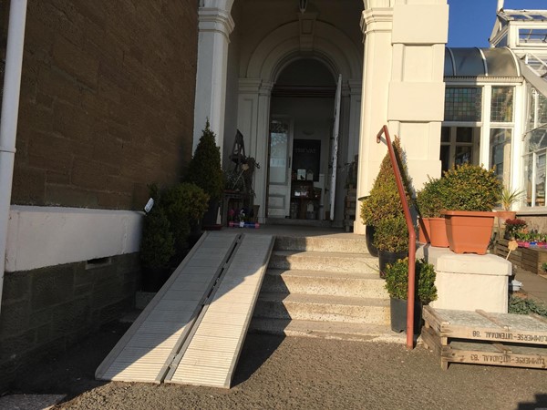 Image of main entrance with ramp and step at doorway.