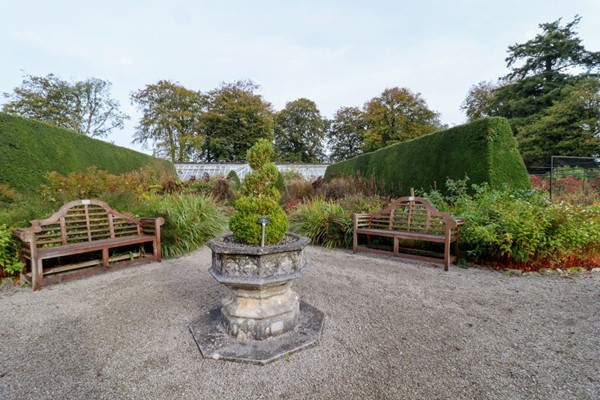 Centre of the walled garden with fine gravel surface and bench seating.