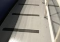 Image of a white railing with black lines on the floor