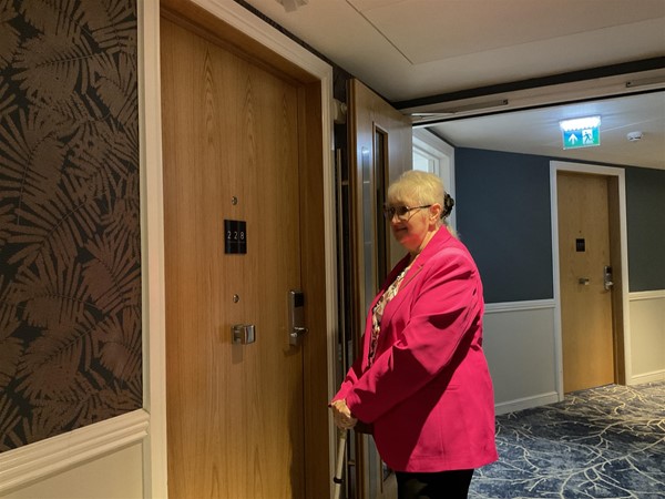 Image of a person at a hotel room door