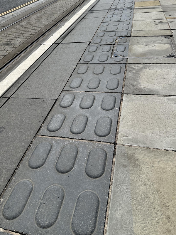 Image of tactile pavement at the edge of the stop