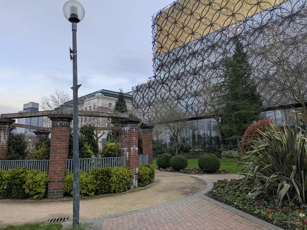 Image of a walkway in the park with the library in the background