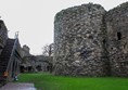 Inside the castle walls, grass surface ahead and a long flight of stone steps up the outer wall on the left.