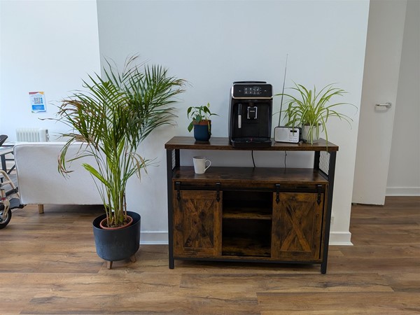 image of a sideboard with a coffee machine, plants and a radio