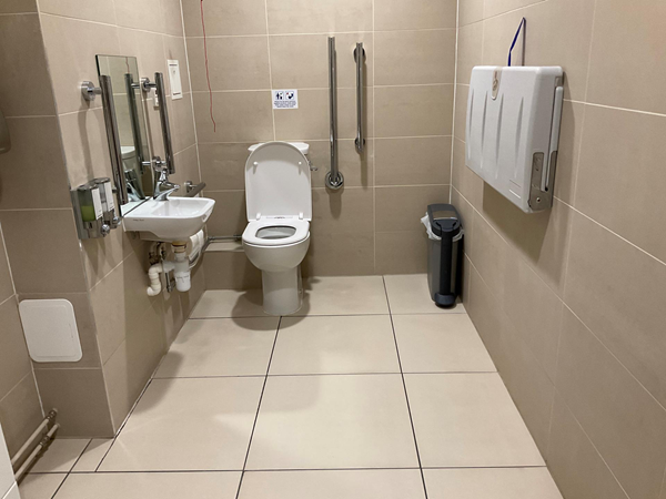 The toilet was quite spacious, clean, nicely tiled, with pull cord and grab rails