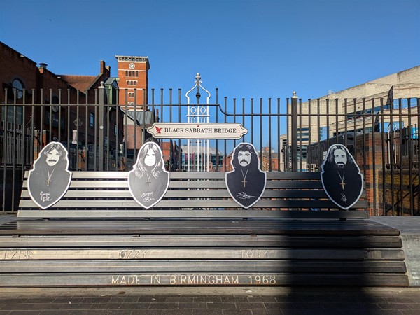 Image of metal bench at  Black Sabbath Bridge showing all band members and their signatures