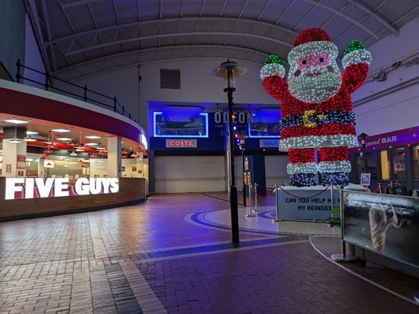 Image of Five Guys and the entrance to the Odeon. There's a large, lit-up Santa on a plinth.