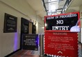 Walkway with a closed gate and a large sign saying Show in progress, no entry.