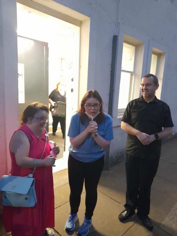 Three people standing in a street