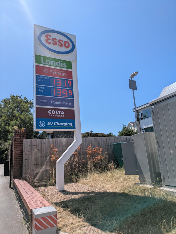 Image of  signage for Esso filling station with fuel prices and signs for Londis, Costa and EV charging.