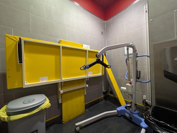 Image of height-adjustable bench in Changing Places Toilet with portable hoist