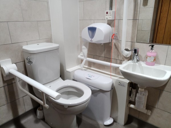 Accessible toilet with handrails and sani-bin. The soap is full and it is nice and clean.