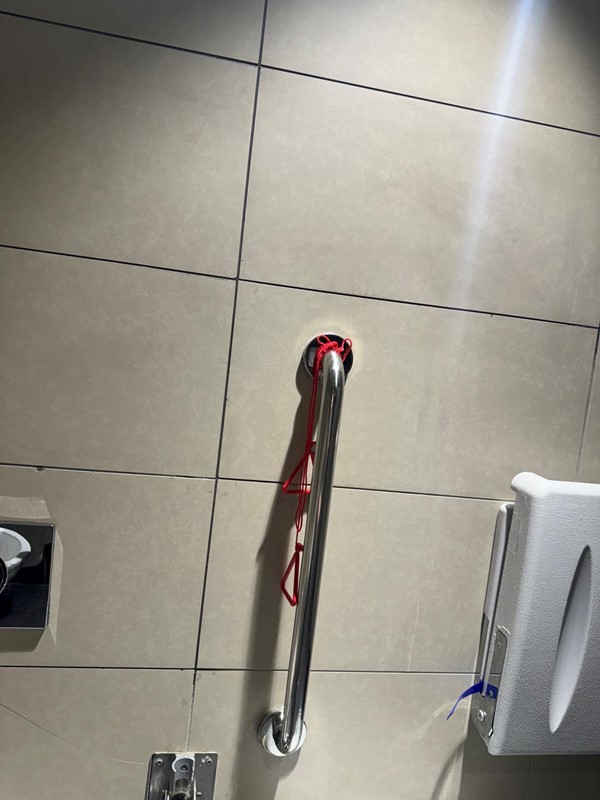 Image of emergency red cord knotted around the hand rail