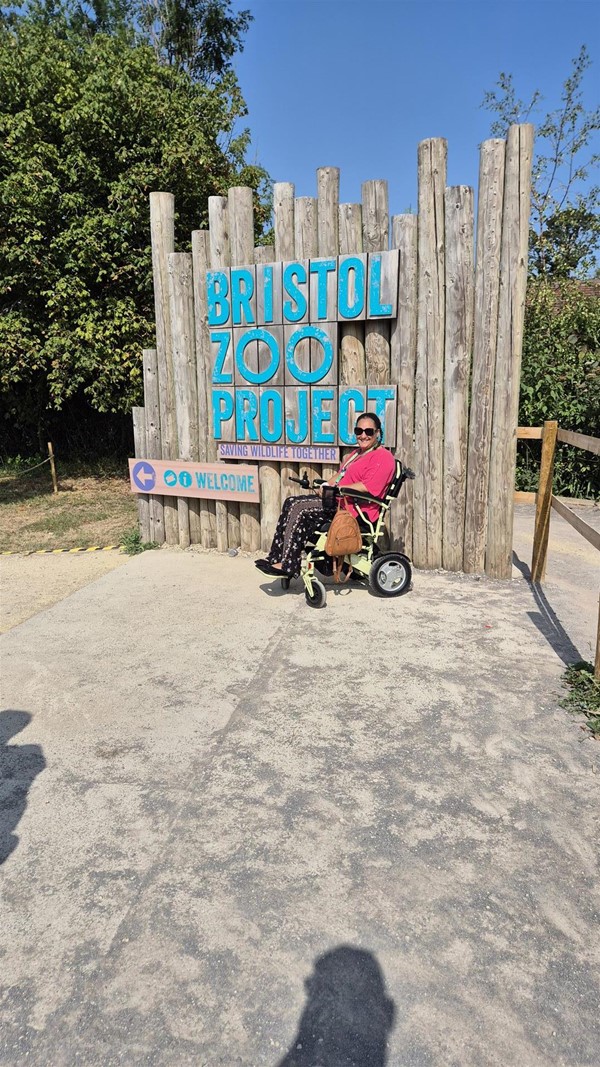 Image of a wheelchair user and the zoo sign