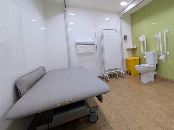 Image of bench, toilet and privacy screen in large Changing Places accessible toilet
